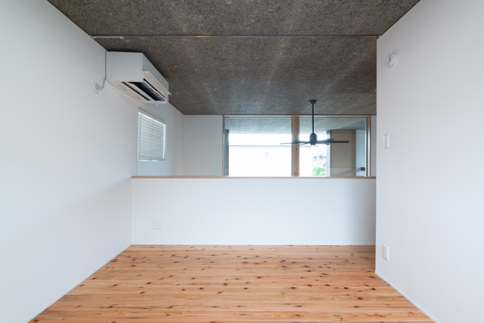 Idéer för funkis huvudsovrum, med vita väggar, brunt golv och mellanmörkt trägolv