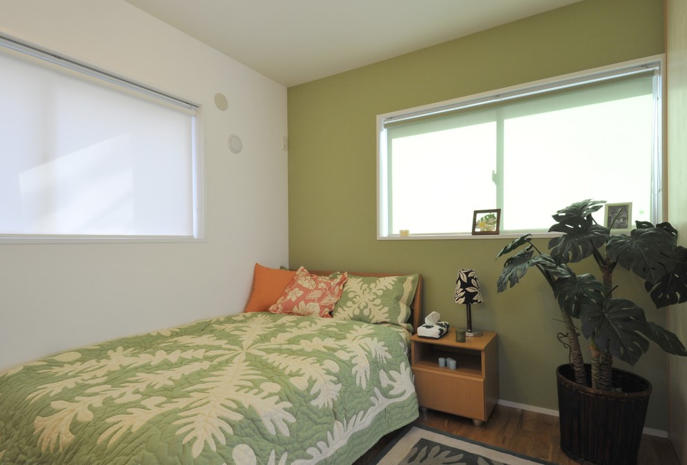 Esempio di una piccola camera matrimoniale contemporanea con pareti verdi, pavimento in legno massello medio e pavimento marrone