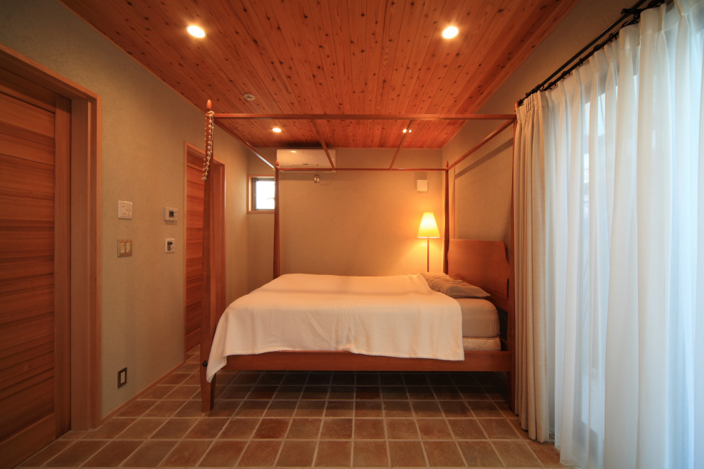 Ispirazione per una camera matrimoniale minimalista con pareti beige, pavimento in terracotta, pavimento beige e soffitto in legno