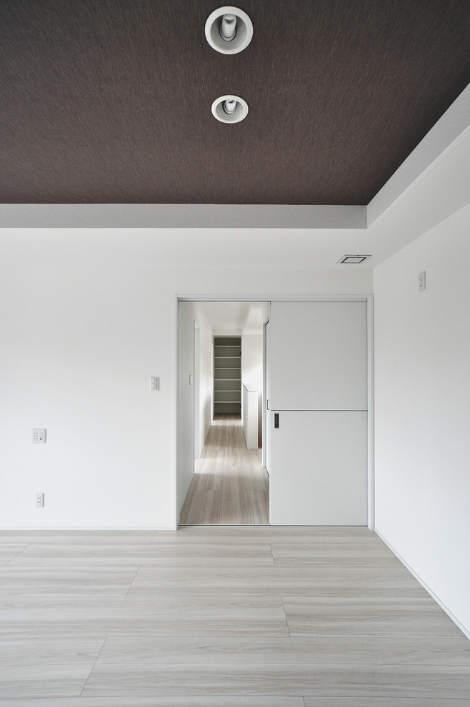 Réalisation d'une chambre parentale minimaliste avec un mur blanc, un sol en contreplaqué et un sol blanc.