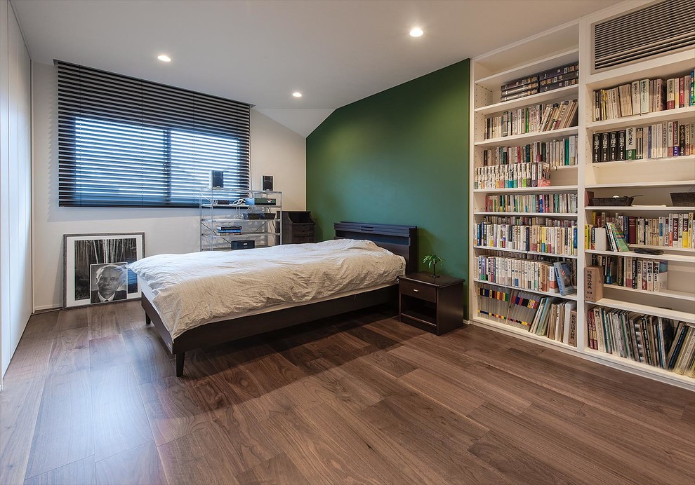 Inspiration pour une chambre parentale minimaliste avec un mur vert, parquet foncé, aucune cheminée et un sol marron.