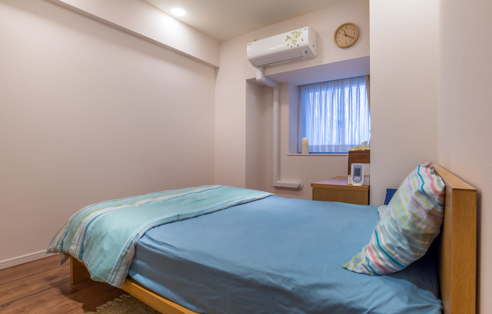 Ejemplo de dormitorio principal escandinavo de tamaño medio sin chimenea con paredes blancas, suelo de contrachapado y suelo marrón