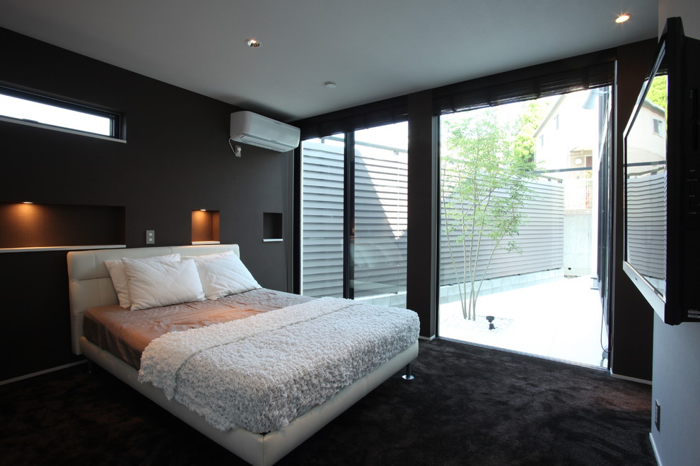Immagine di una camera matrimoniale minimalista di medie dimensioni con pareti nere, moquette e nessun camino