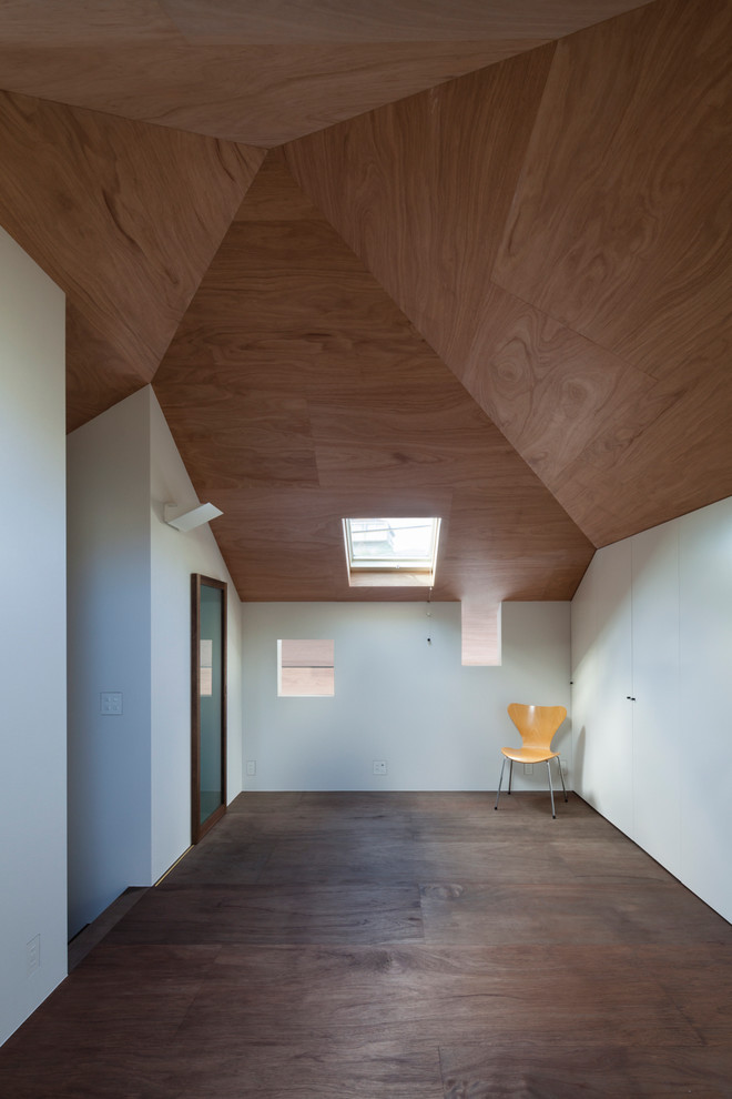 Modelo de dormitorio tipo loft minimalista pequeño sin chimenea con paredes blancas, suelo de contrachapado y suelo marrón