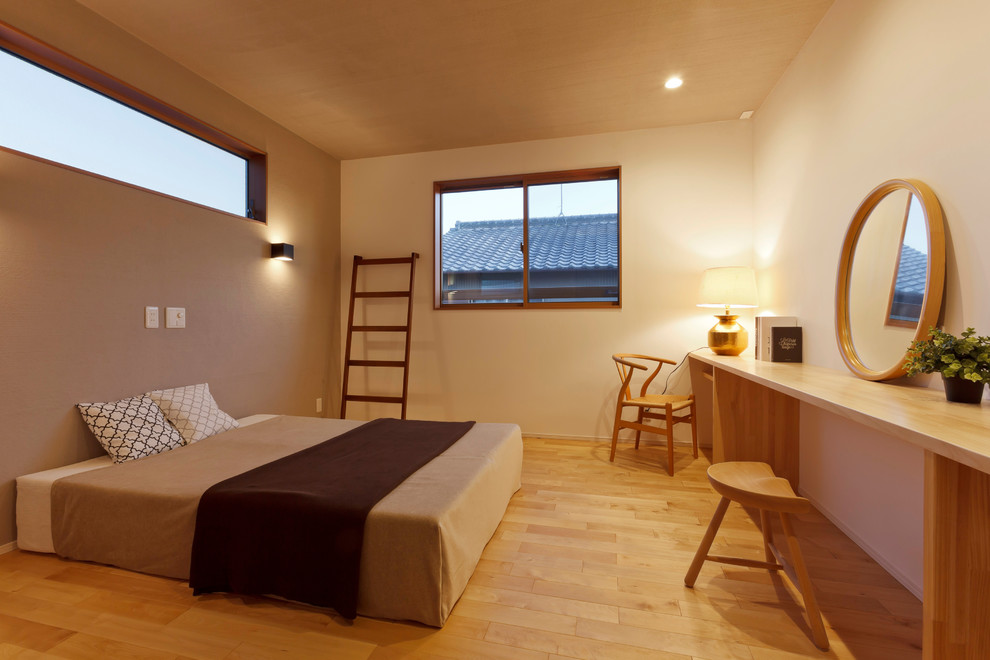 Idee per una camera matrimoniale etnica con pareti beige, pavimento in legno massello medio e pavimento marrone