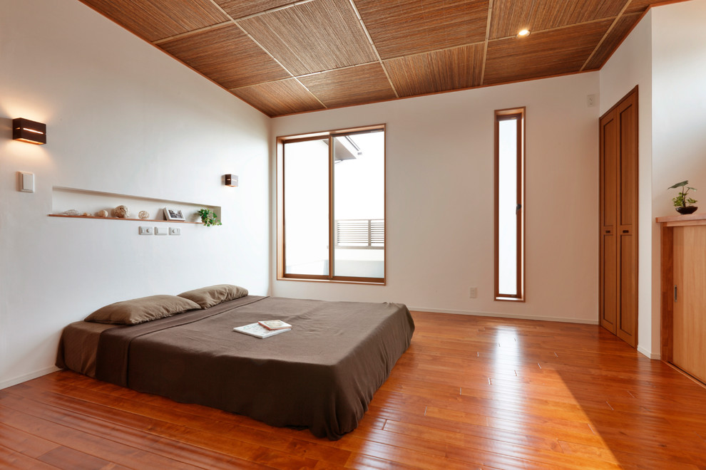 Идея дизайна: хозяйская спальня в восточном стиле с белыми стенами, паркетным полом среднего тона и коричневым полом