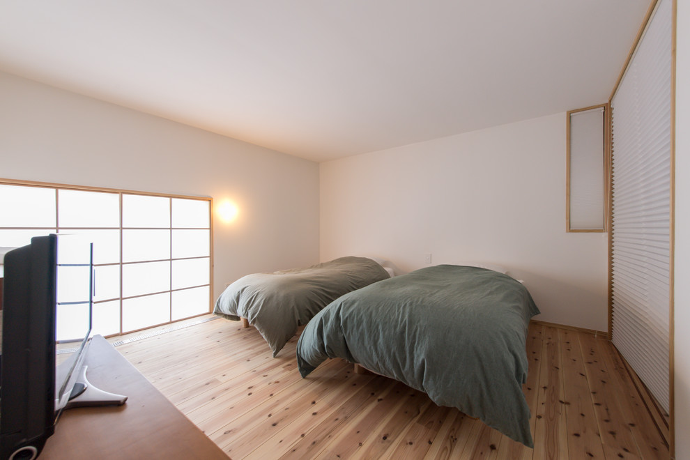 Inspiration för asiatiska sovrum, med vita väggar, ljust trägolv och beiget golv