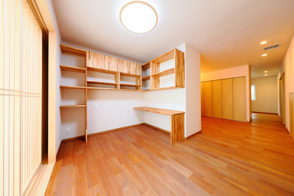 Imagen de dormitorio principal de estilo zen de tamaño medio con paredes blancas y suelo de madera en tonos medios