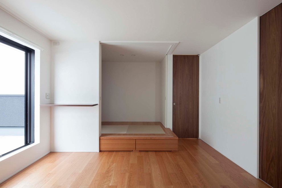 Источник вдохновения для домашнего уюта: большая хозяйская спальня в стиле модернизм с белыми стенами, полом из фанеры и коричневым полом
