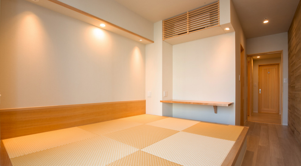 Minimalistisk inredning av ett sovrum, med vita väggar, tatamigolv och gult golv