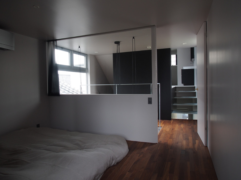 Modernes Hauptschlafzimmer mit grauer Wandfarbe, dunklem Holzboden und braunem Boden in Tokio
