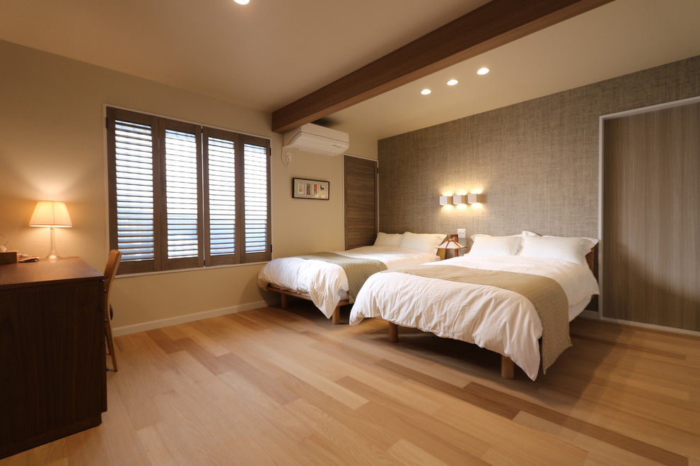 Immagine di una camera da letto moderna con pareti beige, parquet chiaro e pavimento beige