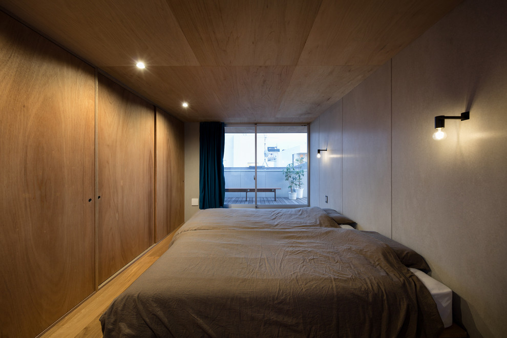 東京23区にあるインダストリアルスタイルのおしゃれな寝室 (グレーの壁、無垢フローリング、茶色い床)