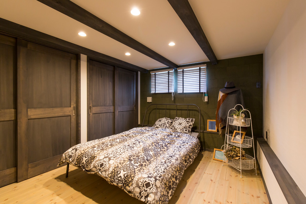 Modelo de dormitorio mediterráneo con paredes verdes, suelo de madera clara y suelo beige