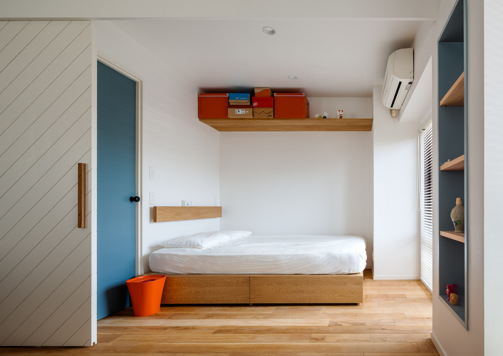 Idée de décoration pour une petite chambre parentale design avec un mur blanc, un sol en bois brun, aucune cheminée et un sol marron.