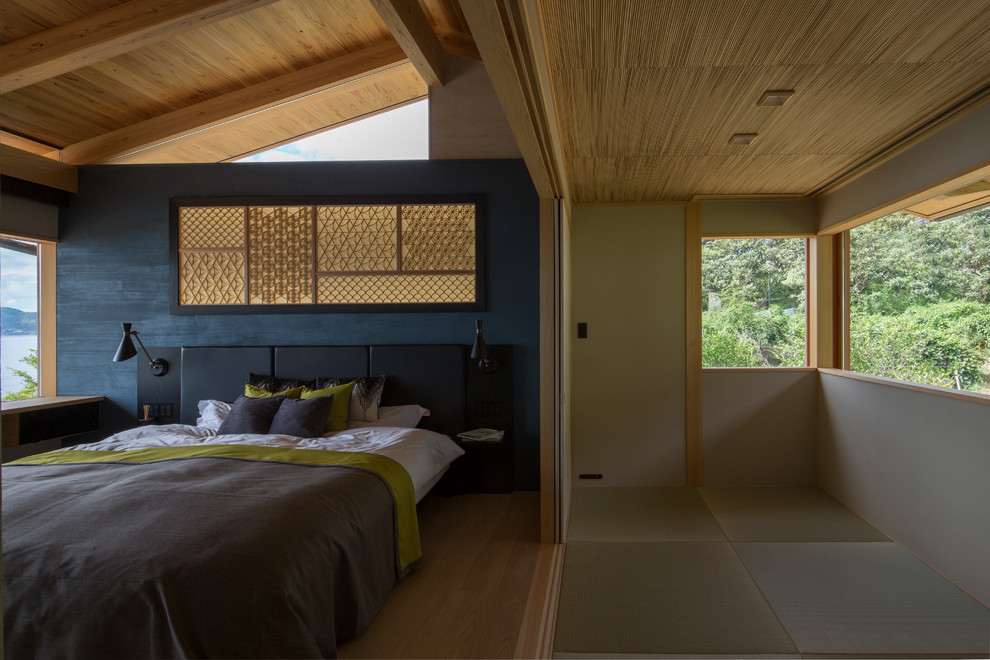 Foto di una camera da letto etnica con pareti blu, pavimento in legno massello medio e pavimento marrone