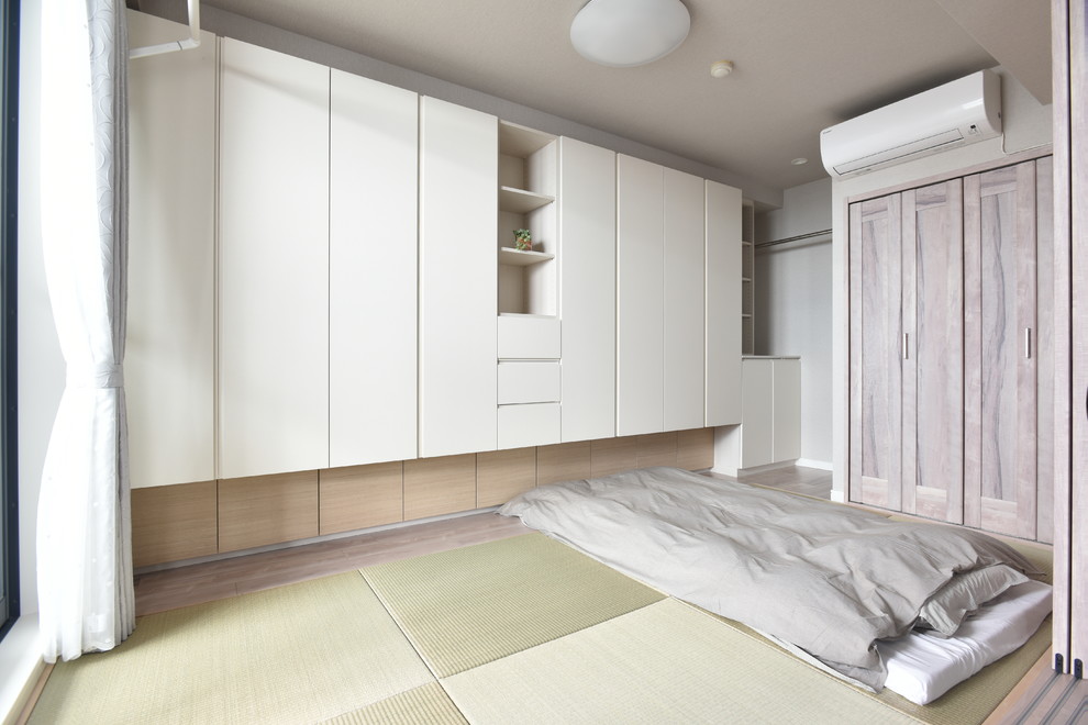 Aménagement d'une chambre asiatique avec un mur blanc, un sol de tatami et un sol vert.
