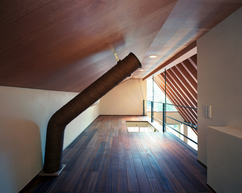 Modelo de dormitorio tipo loft moderno con paredes blancas, suelo de madera oscura, suelo marrón, madera y machihembrado