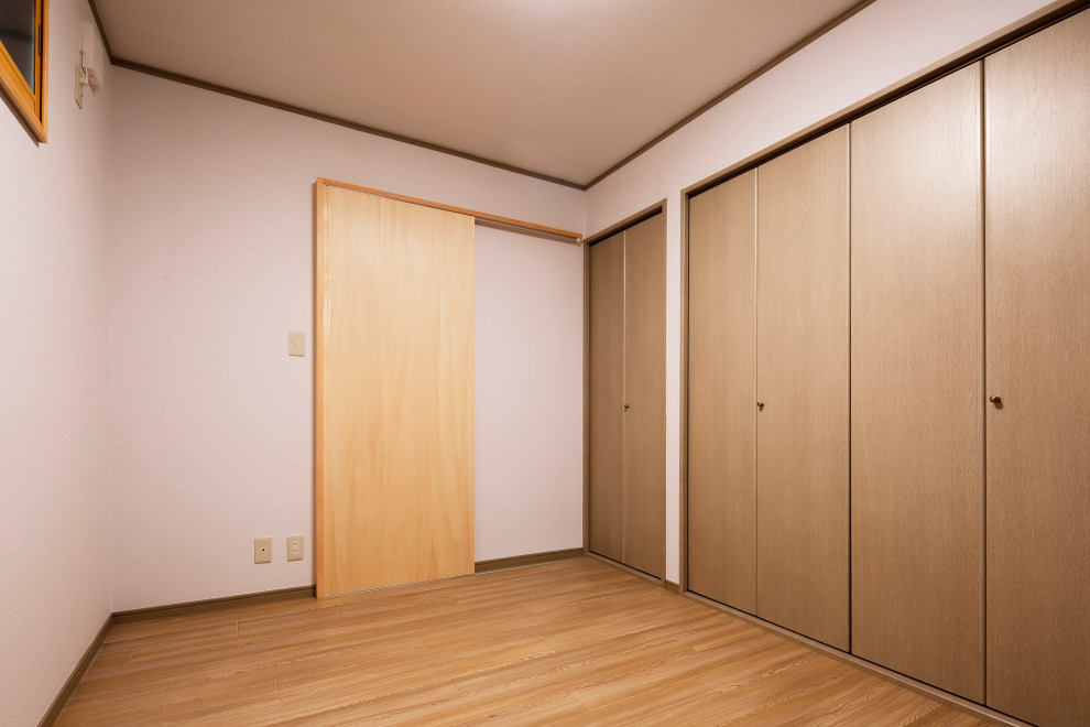 Kleines Modernes Gästezimmer mit weißer Wandfarbe, hellem Holzboden, Tapetendecke und Tapetenwänden in Tokio