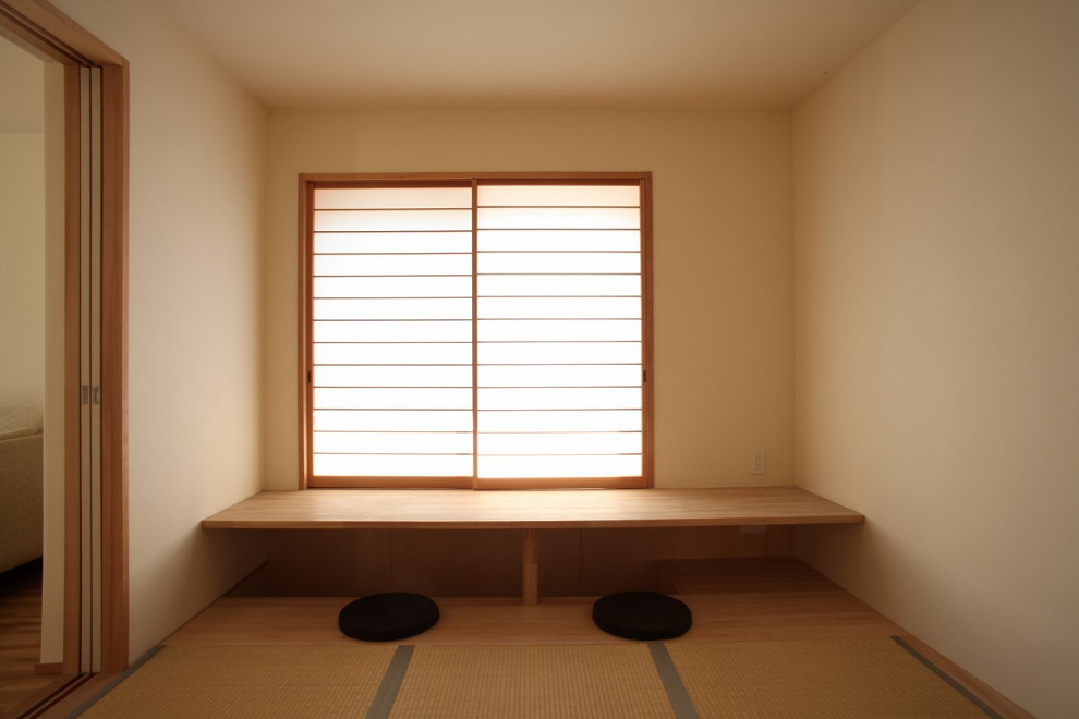 Inredning av ett asiatiskt mellanstort gästrum, med vita väggar, tatamigolv och beiget golv