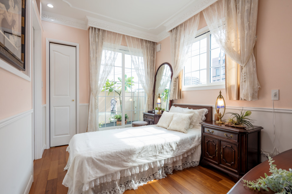 Idée de décoration pour une petite chambre parentale victorienne avec un mur rose, parquet peint et un sol marron.