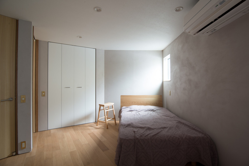 東京23区にある北欧スタイルのおしゃれな主寝室 (グレーの壁、淡色無垢フローリング、茶色い床)