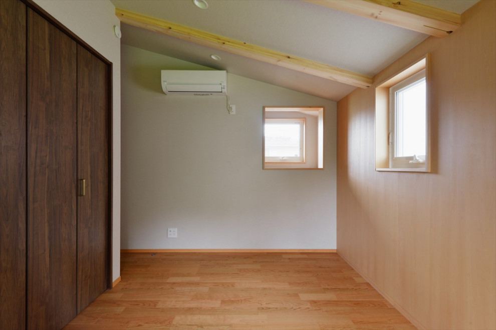 Cette photo montre une chambre moderne en bois avec un sol en contreplaqué et poutres apparentes.