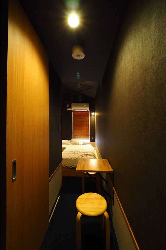 Modelo de dormitorio tipo loft asiático sin chimenea con paredes negras, moqueta y suelo azul