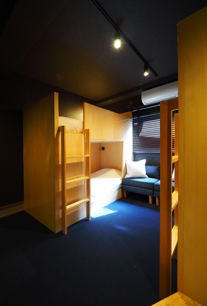 На фото: спальня на антресоли в восточном стиле с черными стенами, ковровым покрытием и синим полом без камина с