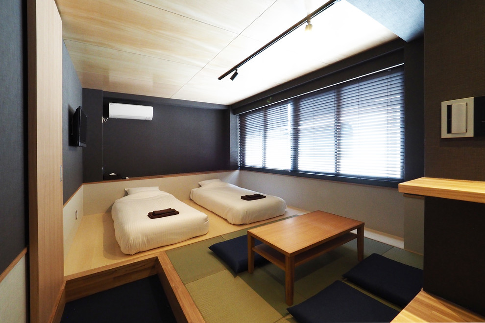 Imagen de habitación de invitados asiática sin chimenea con paredes negras, moqueta y suelo azul