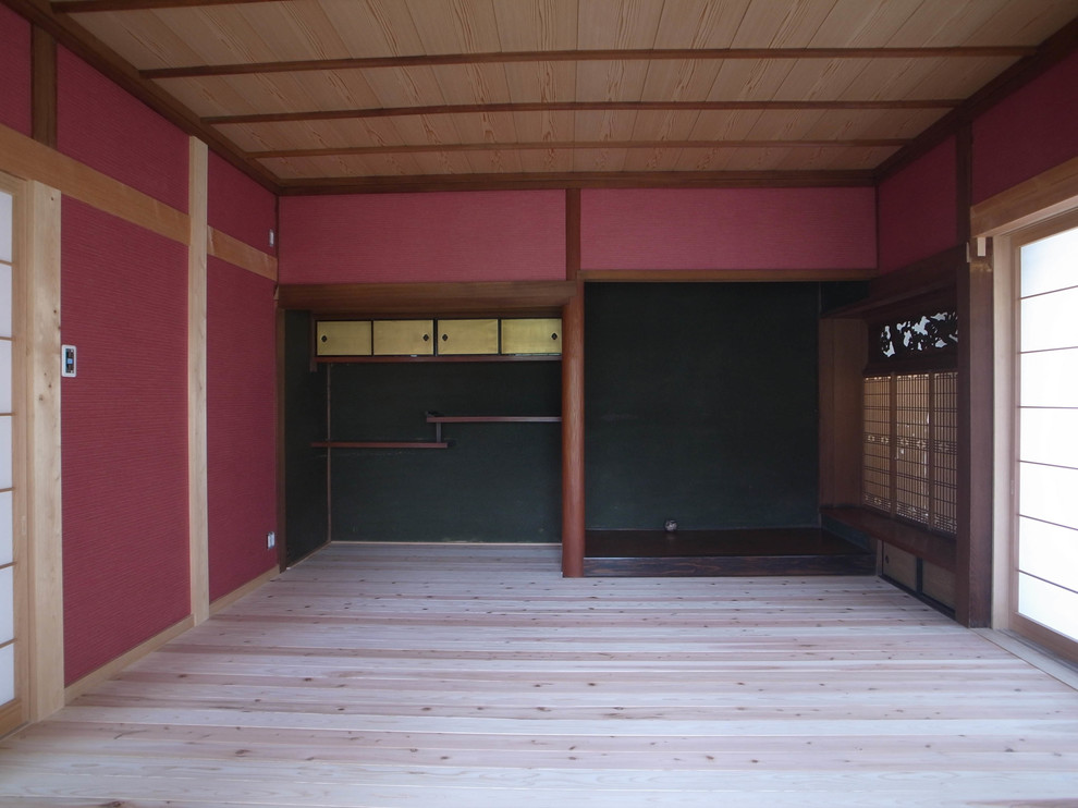 Foto di una camera matrimoniale etnica con pareti rosse, parquet chiaro e pavimento beige