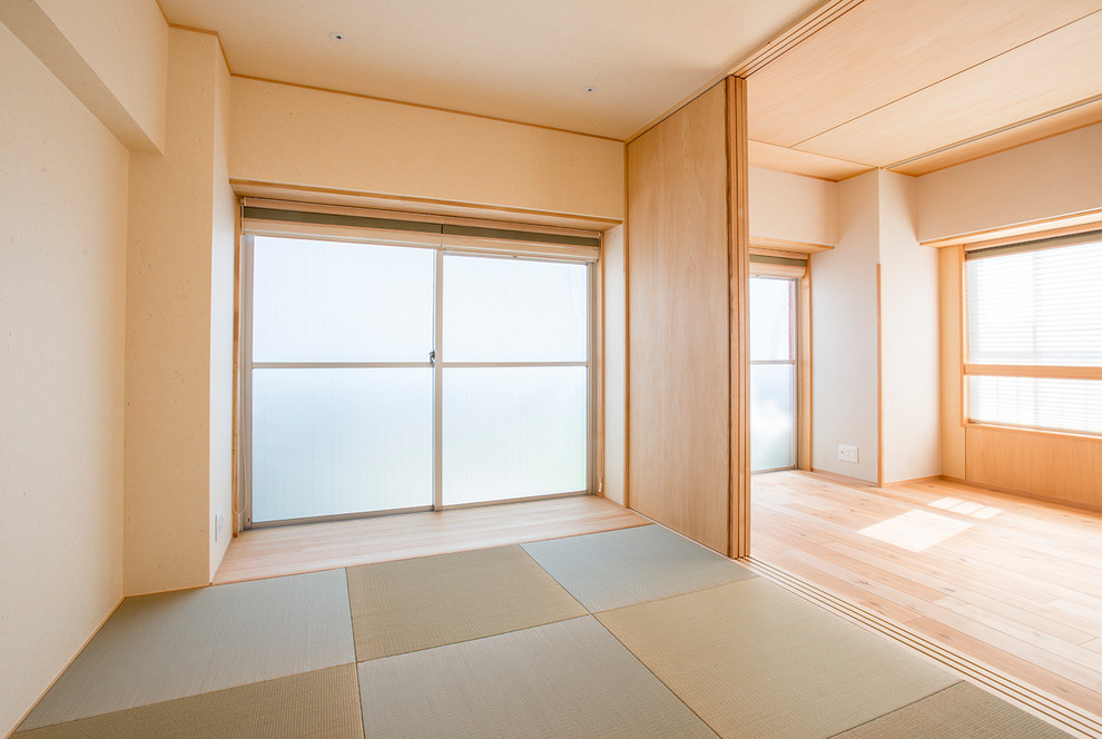 Modernes Hauptschlafzimmer mit beiger Wandfarbe, Tatami-Boden und grünem Boden in Tokio