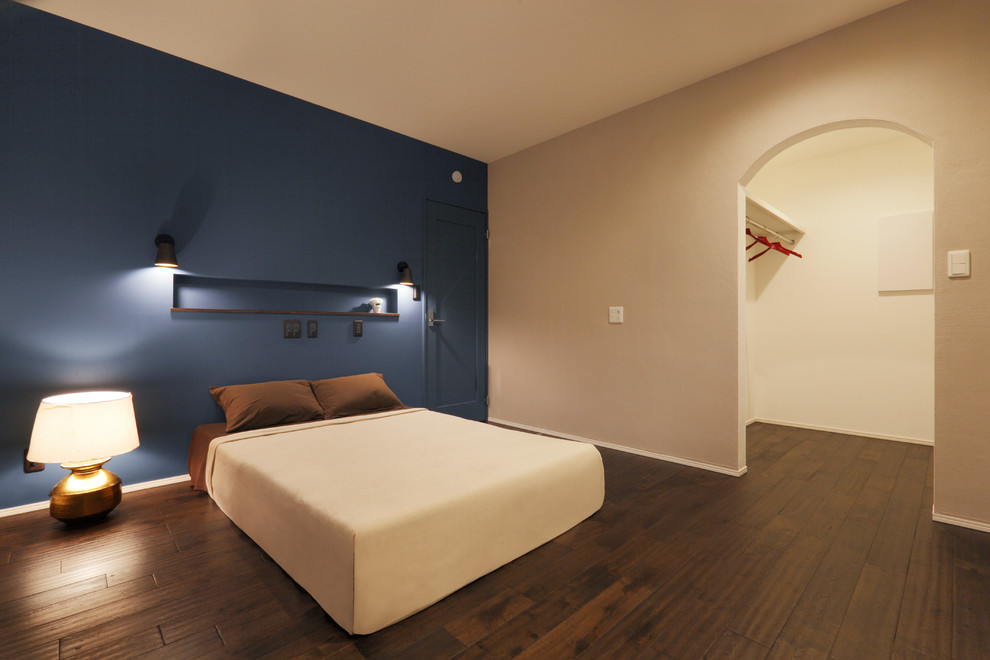 他の地域にあるモダンスタイルのおしゃれな主寝室 (青い壁、濃色無垢フローリング、茶色い床)