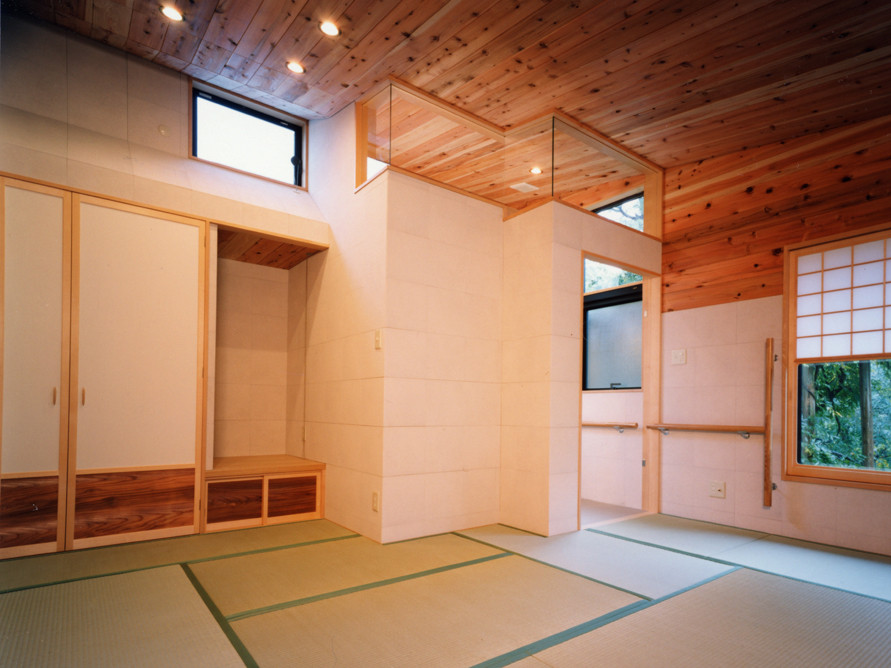 Cette image montre une grande chambre parentale minimaliste en bois avec un mur blanc, un sol de tatami et un plafond en bois.