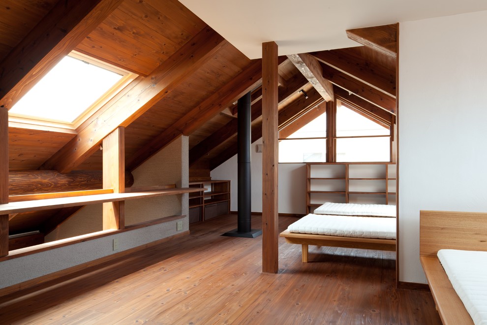 Inredning av ett asiatiskt sovrum, med vita väggar, mörkt trägolv, en öppen vedspis och brunt golv