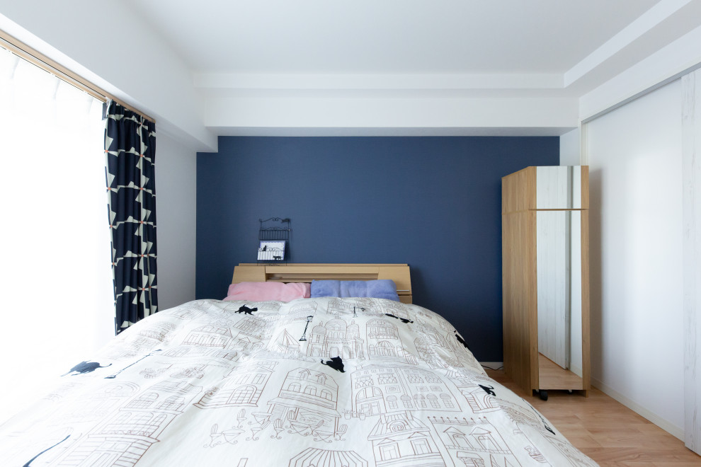 小さなヴィクトリアン調のおしゃれな主寝室 (青い壁、無垢フローリング、ベージュの床) のインテリア