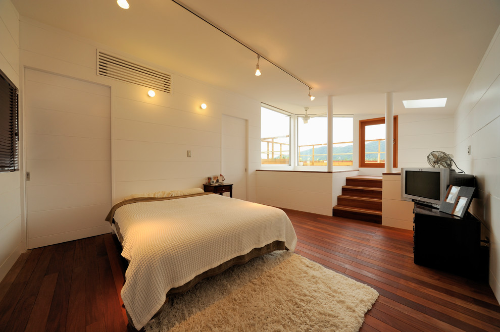 他の地域にあるビーチスタイルのおしゃれな寝室 (白い壁、濃色無垢フローリング、茶色い床) のレイアウト