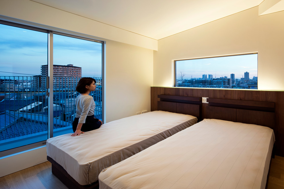 На фото: хозяйская спальня среднего размера в стиле модернизм с белыми стенами и полом из фанеры без камина с