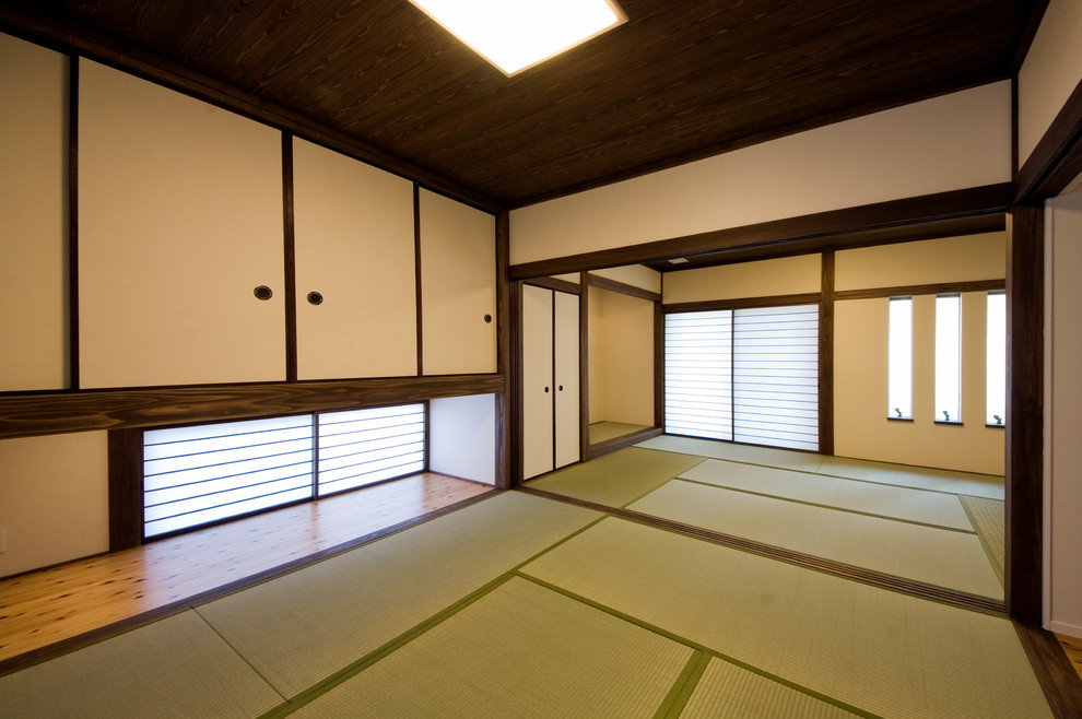 Cette image montre une chambre d'amis asiatique avec un mur blanc et un sol de tatami.