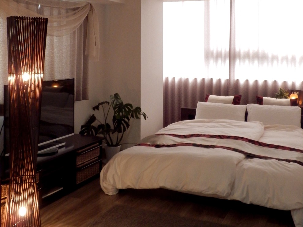 Diseño de dormitorio principal de estilo zen de tamaño medio con paredes blancas, suelo vinílico y suelo marrón