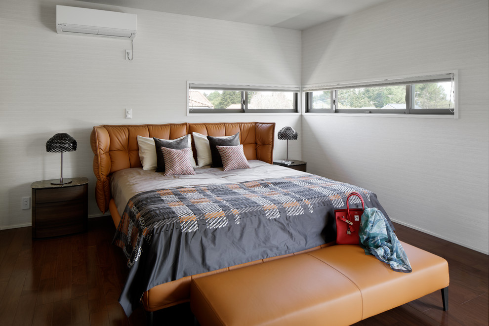 Diseño de dormitorio principal contemporáneo de tamaño medio sin chimenea con paredes beige, suelo de contrachapado y suelo marrón