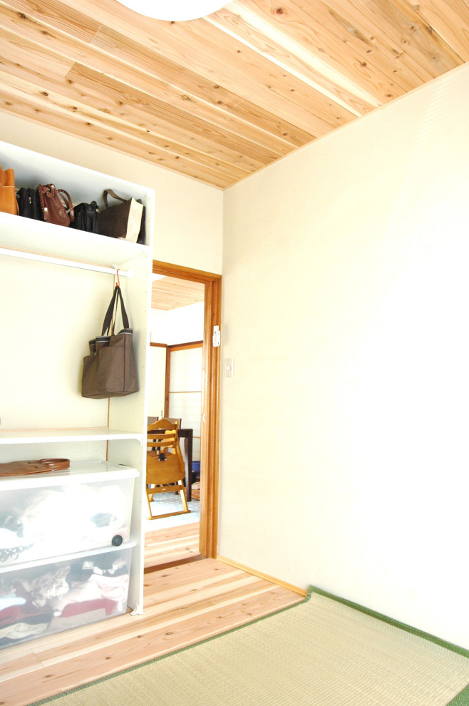 Immagine di una piccola camera matrimoniale etnica con pareti bianche, pavimento in legno massello medio, pavimento marrone e soffitto in legno