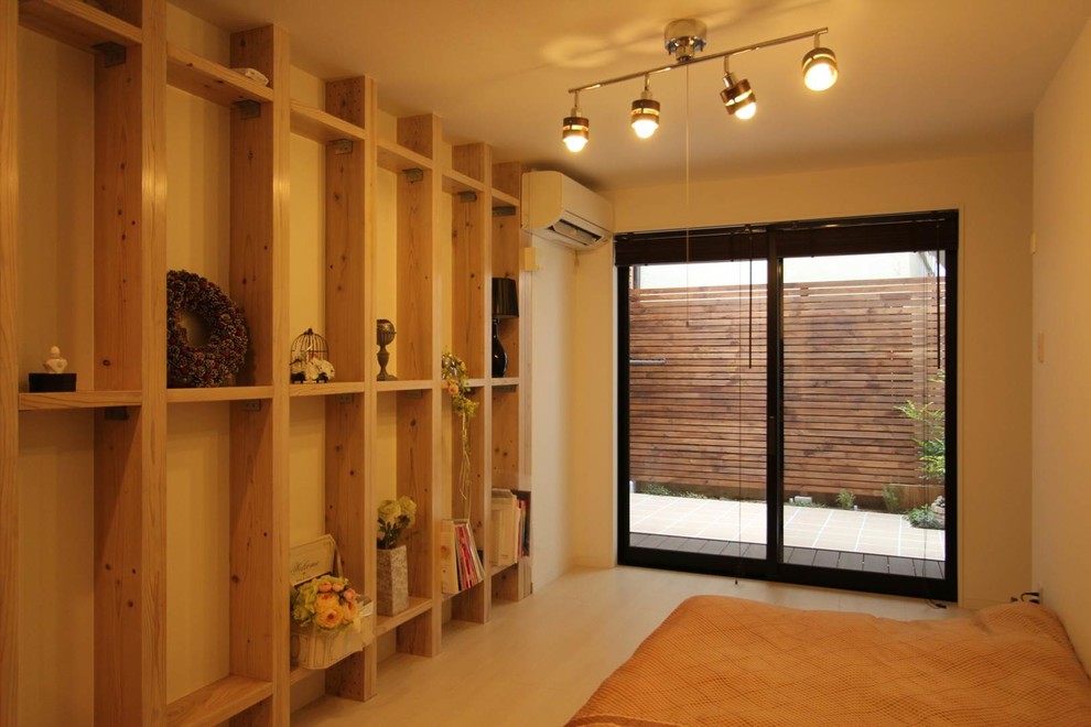 Cette photo montre une petite chambre parentale tendance avec un mur blanc, parquet clair et un sol beige.