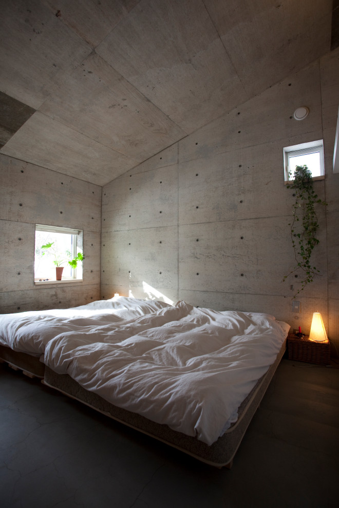 Bild på ett industriellt sovrum, med grå väggar, mörkt trägolv och brunt golv