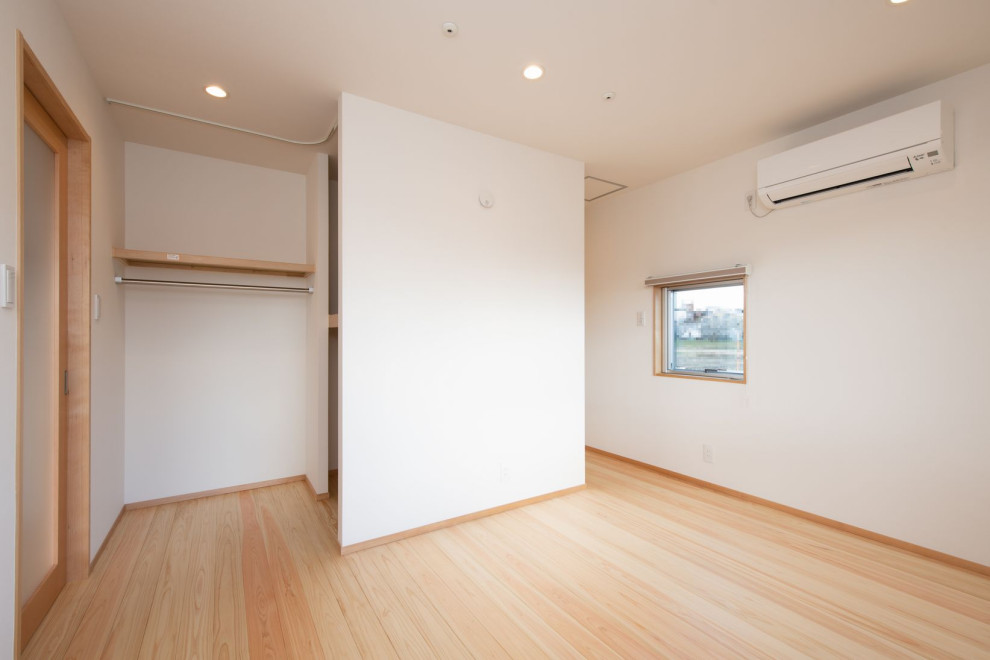 Diseño de dormitorio principal escandinavo de tamaño medio con paredes blancas, suelo de madera en tonos medios y suelo beige