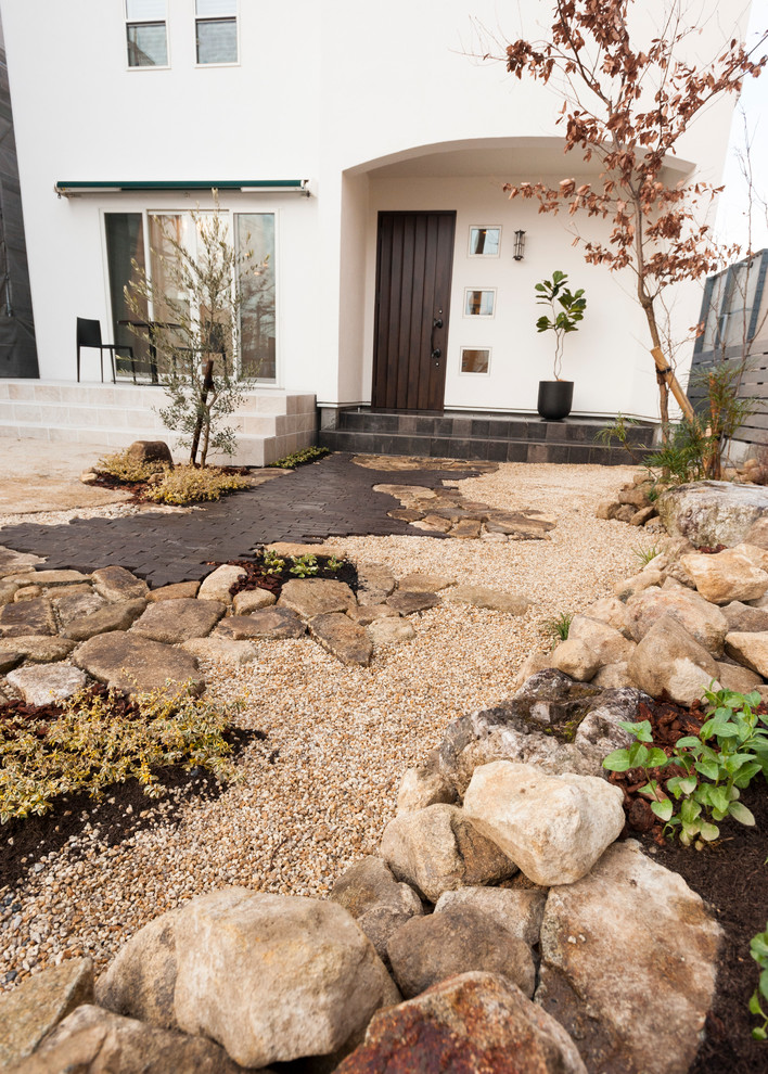 Modelo de jardín de secano nórdico en patio delantero con adoquines de piedra natural