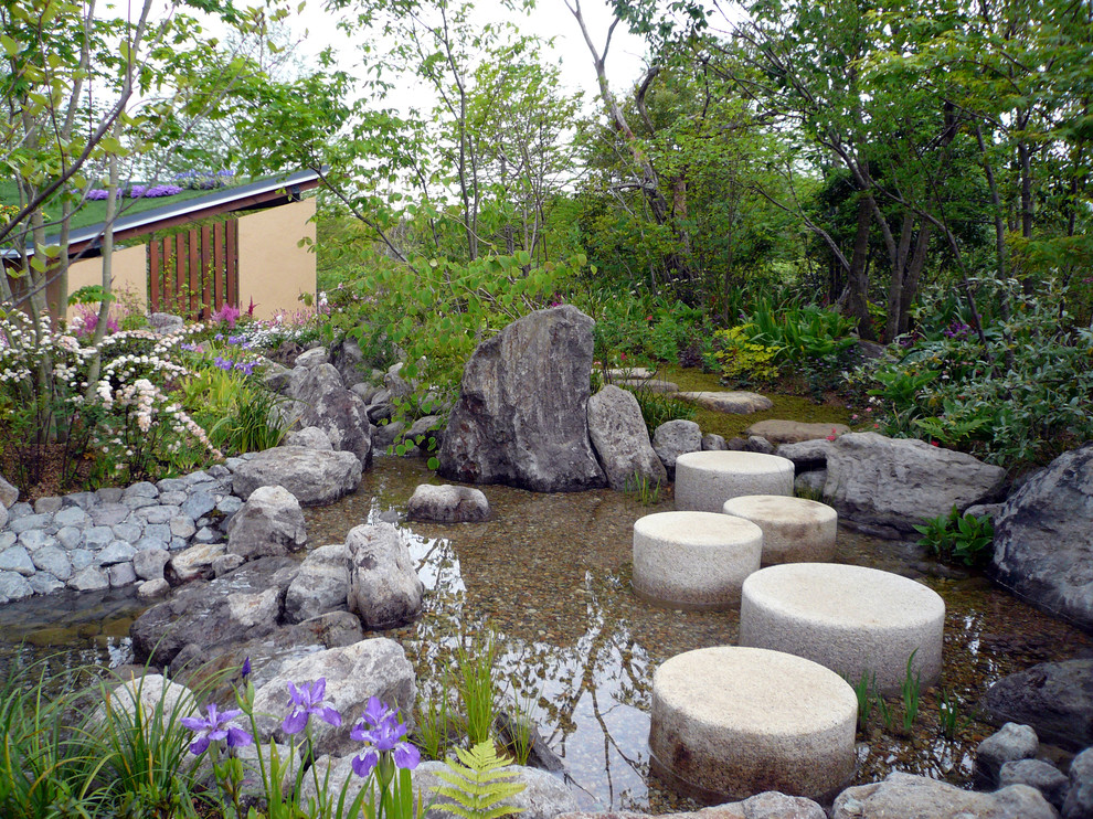 Réalisation d'un jardin avec un bassin et des pavés en pierre naturelle.