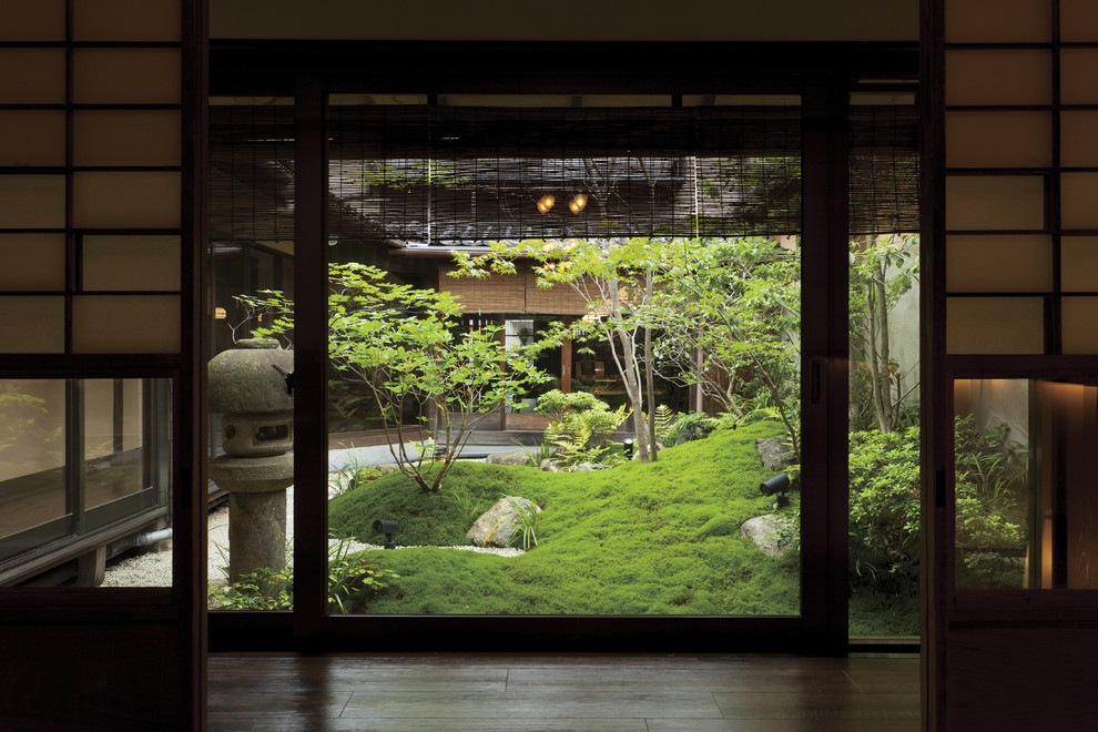 Large world-inspired courtyard formal full sun garden in Osaka with gravel.