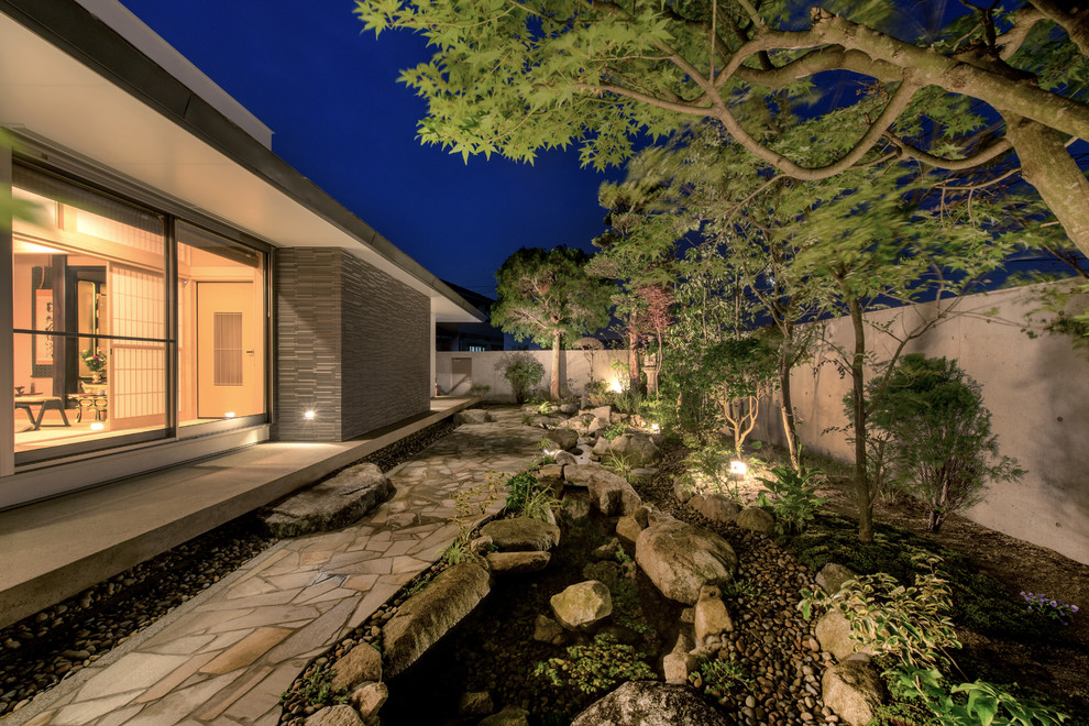 На фото: участок и сад на заднем дворе в восточном стиле с садовой дорожкой или калиткой и покрытием из каменной брусчатки с