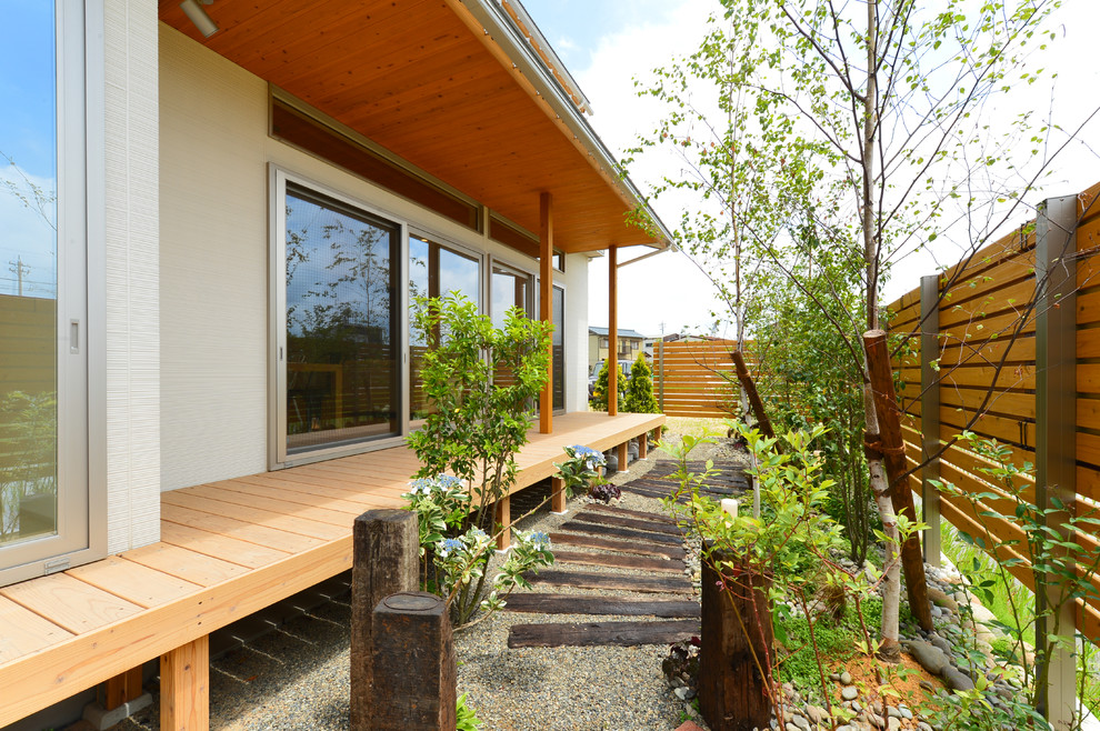 Exemple d'un jardin latéral asiatique avec une exposition ensoleillée et une terrasse en bois.